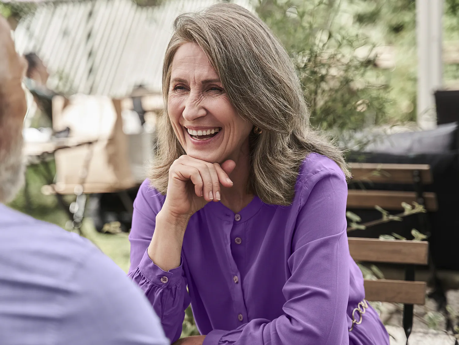 Woman laughing out loud with her beloved husband while wearing hearing aids